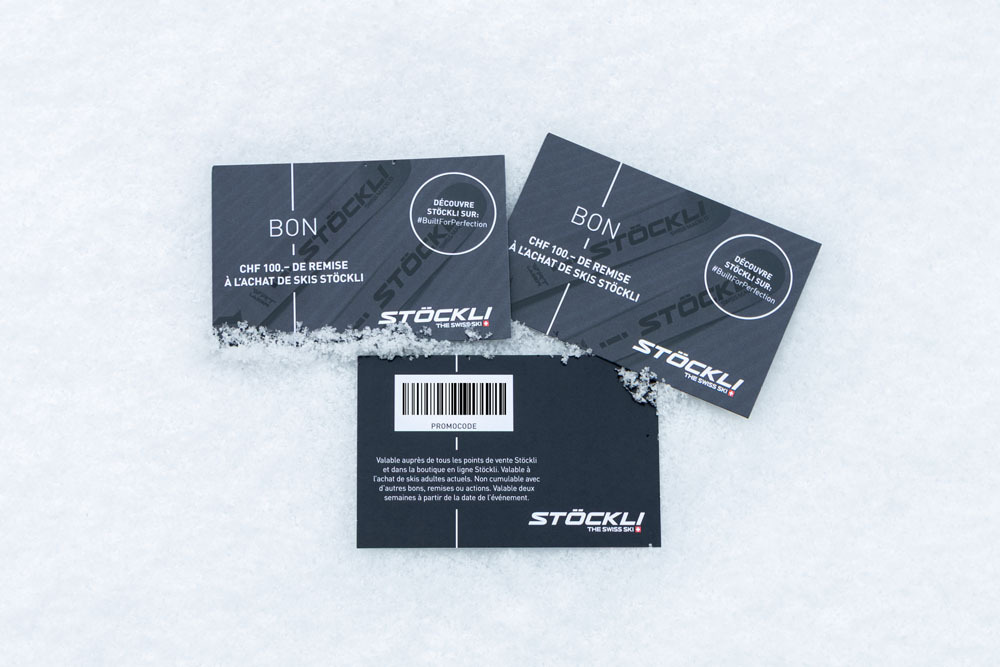 Drei Skigutscheine auf Schnee mit der Marke „Stöckli“ und einem Rabattangebot von CHF 100.–. Die Gutscheine sind mit einem Barcode, einem Werbetext und einem Logo versehen.