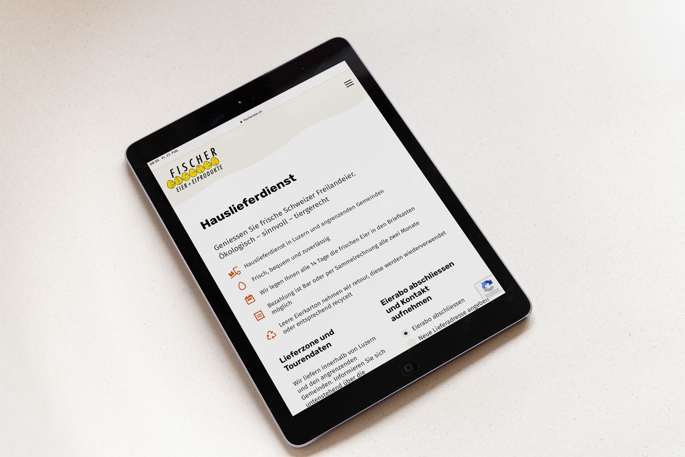 Tablet mit der deutschsprachigen Website des Fischer Gewürzkontors, auf der Dienstleistungen wie Hauslieferung und Großbestellungen beschrieben werden. Auf dem Bildschirm sind Symbole und Text vor hellem Hintergrund zu sehen.