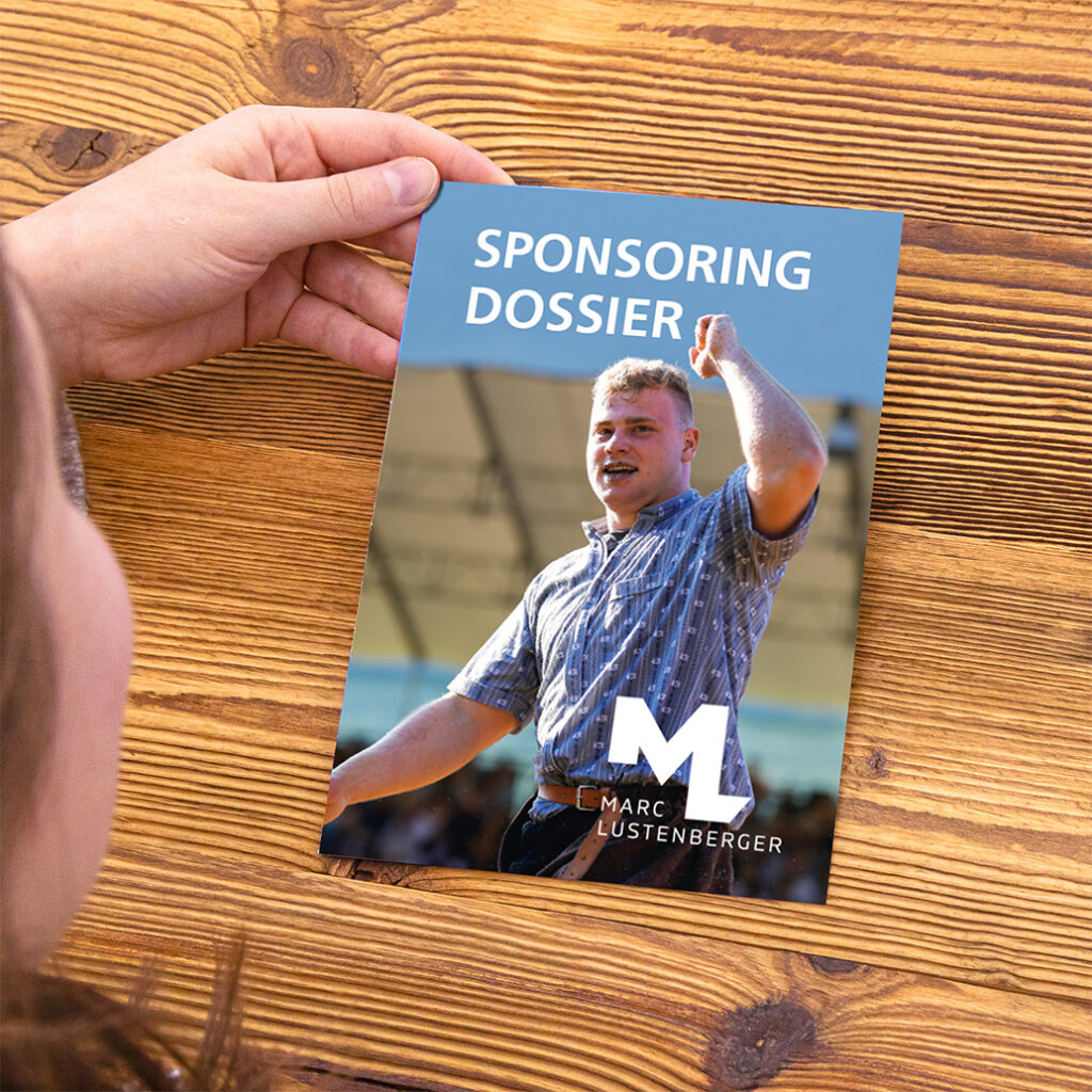 Eine Person hält eine Broschüre mit dem Titel „SPONSORING DOSSIER“ in der Hand. Darauf ist ein Mann in einem blauen Hemd abgebildet. Auf dem Cover sind außerdem die Initialen „ML“ und der Name „Marc Lustenberger“ zu sehen. Der Hintergrund ist eine Holzoberfläche.