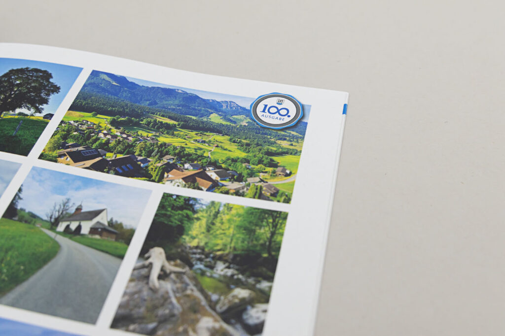 Eine Broschürenseite zeigt malerische Bilder, darunter ein Dorf in einem grünen Tal, eine Landstraße und einen Waldbach. In der oberen rechten Ecke befindet sich ein kreisförmiges Logo mit der Aufschrift „100 Österreich“. Der Hintergrund ist schlicht hellgrau.