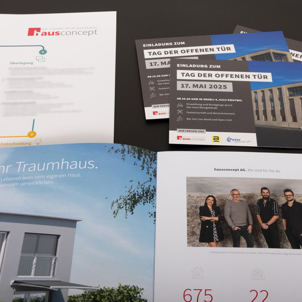 Auf schwarzem Untergrund präsentierten sich Broschüren und Flyer von „hausconcept“, darunter Eventeinladungen, Visitenkarten und ein Magazin mit Fotos, Texten und Bildern von Menschen und einem modernen Haus.