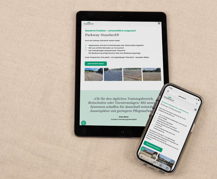 Ein Tablet und ein Smartphone, die dieselbe Website anzeigen, sind auf einer beigen Stoffoberfläche platziert. Auf den Bildschirmen sind Texte und Bilder zu den Normen für Straßenbeläge zu sehen.