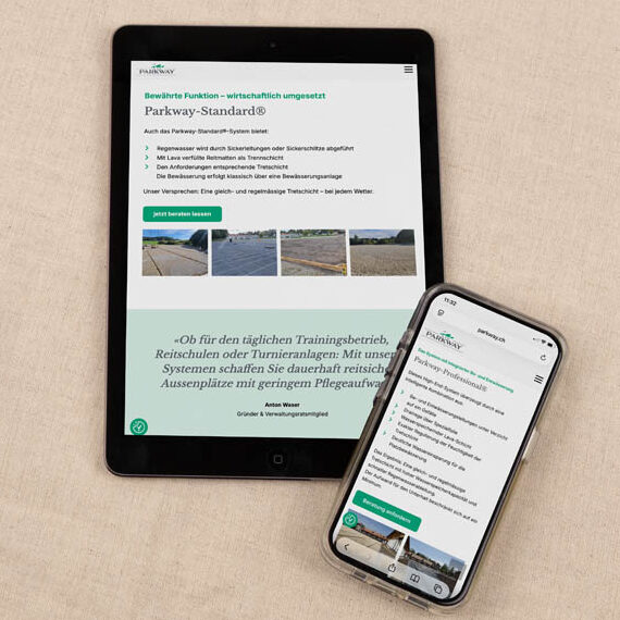 Ein Tablet und ein Smartphone, die dieselbe Website anzeigen, sind auf einer hellbeigen Stoffoberfläche platziert. Die Bildschirme zeigen Bilder und Texte zu Straßen- und Gehwegnormen.
